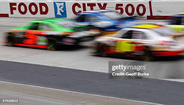 Mark Martin, driver of the GoDaddy.com Chevrolet, races Kurt Busch, driver of the Miller Lite Dodge, and Greg Biffle, driver of the US Census Ford,...
