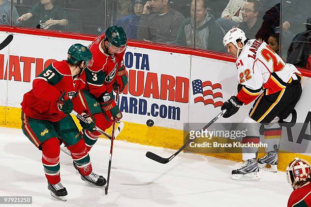 James Sheppard and Marek Zidlicky of the Minnesota Wild battle for a loose puck with Daymond Langkow of the Calgary Flames during the game at the...