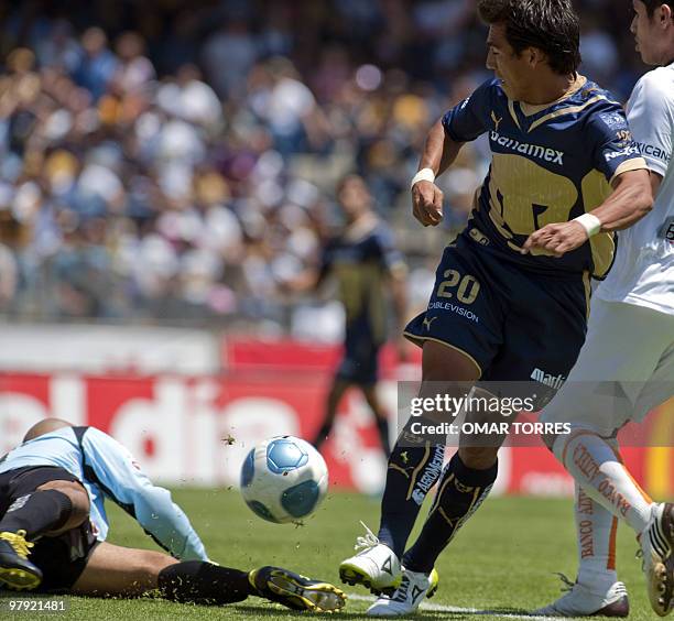 Ismael Iniguez of Pumas shoots next to Jaguares' goalkeeper Oscar Perez during their Mexican Bicentenario 2010 tournament football match on March 21,...