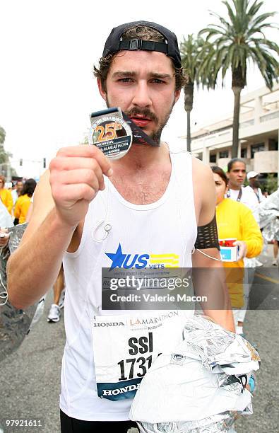 Actor Shia Laboeuf shows his medal as he crosses the finish line of the 25th L.A. Marathon on March 21, 2010 in Santa Monica, California.