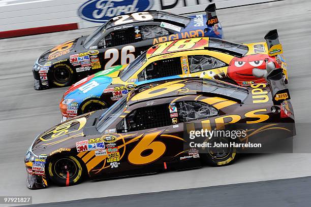 David Ragan, driver of the UPS Ford, races Kyle Busch, driver of the M&M's Toyota, and David Stremme, driver of the Sacred Power Ford, during the...