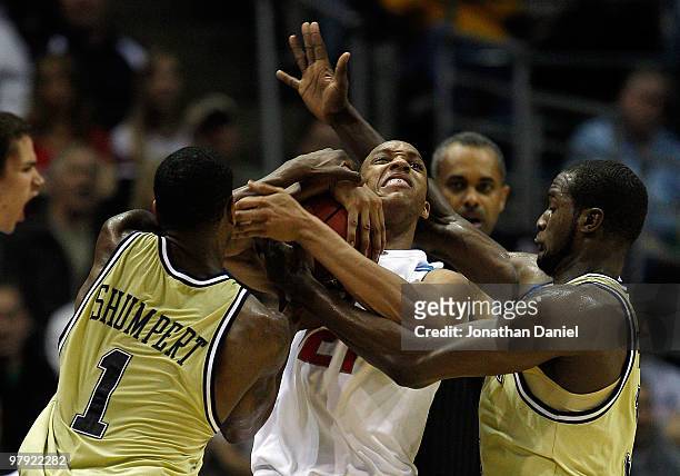 Evan Turner of the Ohio State Buckeyes is double-teammed by Iman Shumpert and Zachery Peacock of the Georgia Tech Yellow Jackets in the second half...