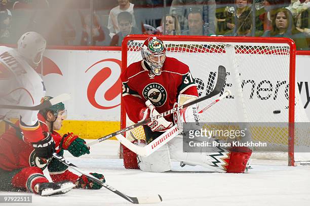 Ian White of the Calgary Flames scores a goal against Josh Harding of the Minnesota Wild during the game at the Xcel Energy Center on March 21, 2010...