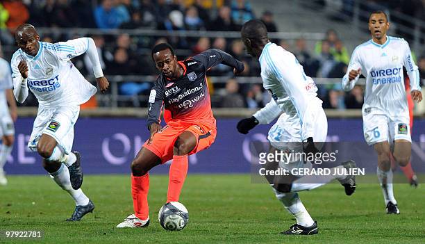 Lyon's forward Sydney Govou vies with Marseille's Cameroonian midfielder Stephane M'Bia and Senegalese defender Souleymane Diawara during their...