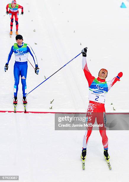 Yoshihiro Nitta of Japan celebrates as he crosses the line ahead of Kirii Mikhaylov of Russia to win gold in the Men's 1km Standing Cross-Country...