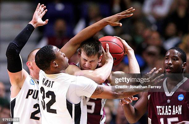 Nathan Walkup of the Texas A&M Aggies is defended by John Hart and D.J. Byrd of the Purdue Boilermakers during the second round of the 2010 NCAA...