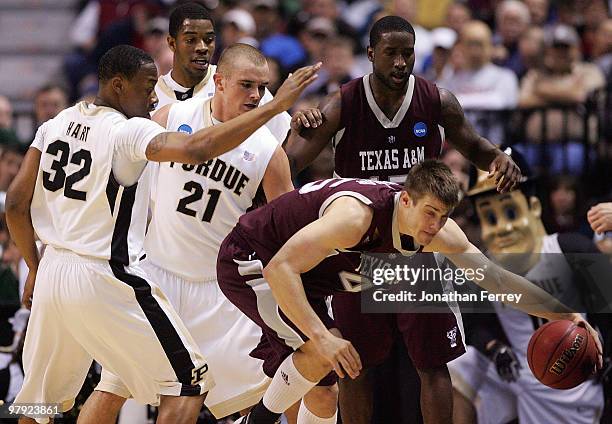 Nathan Walkup of the Texas A&M Aggies is defended by John Hart and D.J. Byrd of the Purdue Boilermakers during the second round of the 2010 NCAA...