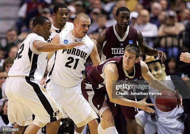 Nathan Walkup of the Texas A&M Aggies is defended by John Hart and D.J. Byrd of the Purdue Boilermakers during the second round of the 2010 NCAA...