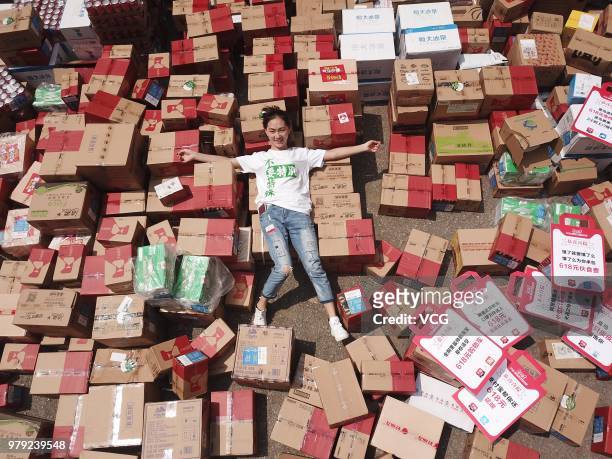 Sophomore student poses with her 618 delivery parcels during the '618' shopping festival on June 18, 2018 in Nanjing, Jiangsu Province of China. The...