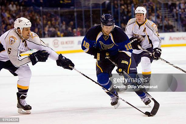 Jay McClement of the St. Louis Blues moves the puck up ice against Shea Weber of the Nashville Predators at the Scottrade Center on March 21, 2010 in...