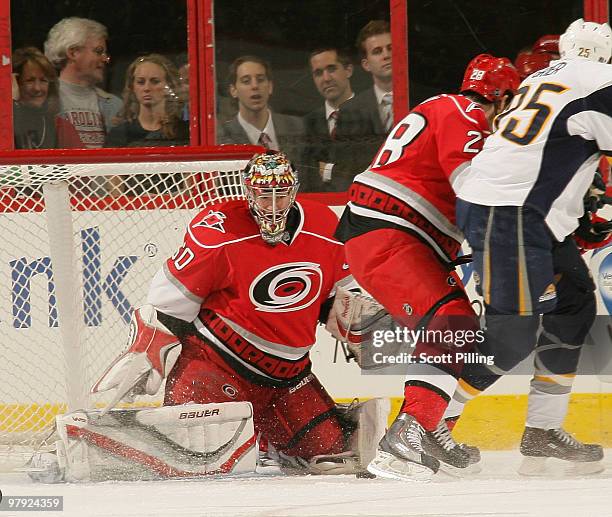 Justin Peters of the Carolina Hurricanes keeps his eye on the puck with lots of traffic in front of him against the Buffalo Sabres during their NHL...