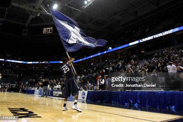 Dante Jackson of the Xavier Musketeers picks up the team flag and celebrates after defeating the Pittsburgh Panthers during the second round of the...