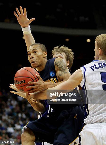 Jerome Randle of the California Golden Bears tries to drive between Mason Plumlee and Kyle Singler of the Duke Blue Devils during the second round of...