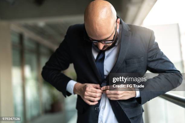 businessman getting dressed - adjusting suit stock pictures, royalty-free photos & images