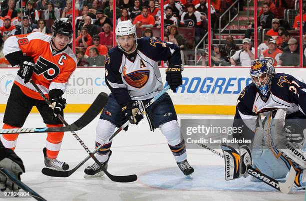 Mike Richards of the Philadelphia Flyers battles for position in front of goaltender Ondrej Pavelec of the Atlanta Thrashers with Zach Bogosian on...