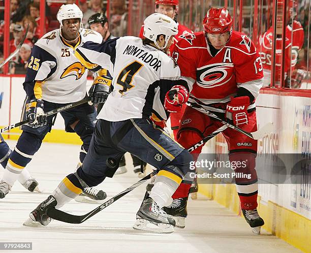 Ray Whitney of the Carolina Hurricanes takes a hit along the boards by Steve Montador of the Buffalo Sabres during their NHL game on March 21, 2010...