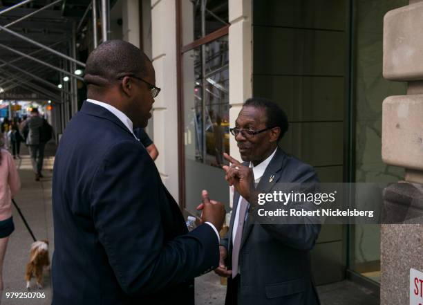 Two men speak on the sidewalk June 14, 2018 in New York City.