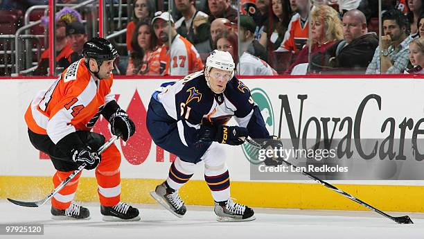 Maxim Afinogenov of the Atlanta Thrashers skates with the puck while being pursued by Ian Laperriere of the Philadelphia Flyers on March 21, 2010 at...