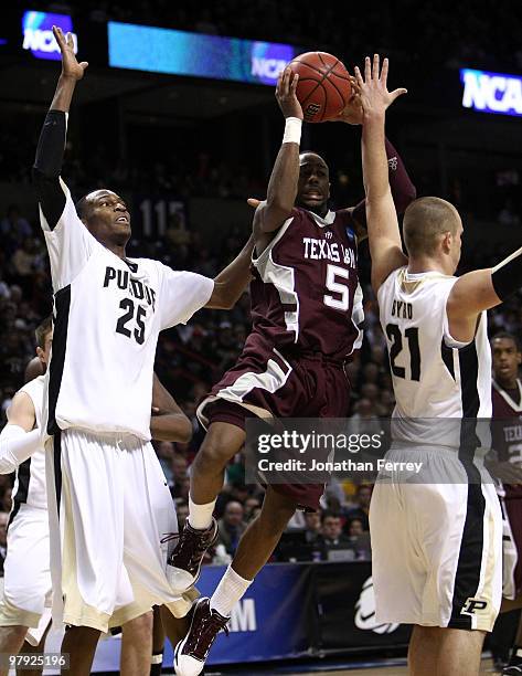 Dash Harris of the Texas A&M Aggies drives against JaJuan Johnson and D.J. Byrd of the Purdue Boilermakers during the second round of the 2010 NCAA...