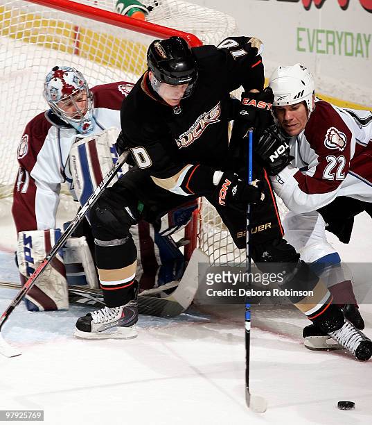 Corey Perry of the Anaheim Ducks battles for the puck outside the crease against Scott Hannan and Craig Anderson of the Colorado Avalanche during the...