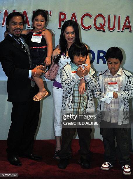 Filipino boxing superstar Manny Pacquiao holding his daughter Princess, poses for photos with his wife Jinkee , sons Jimuel and Michael during a...