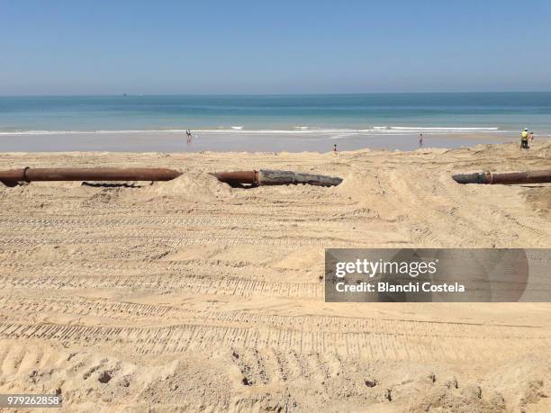 installing pipes on the beach - el-puerto-de-santa-maría photos et images de collection