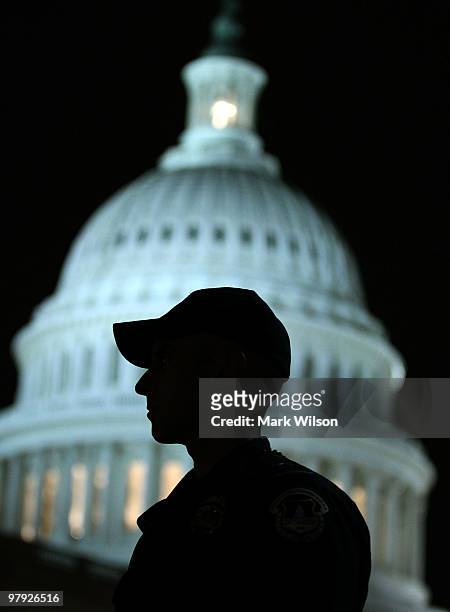 Capitol Police Officer Joe Bigio stands watch in front of the US Capitol on March 21, 2010 in Washington, DC. Later tonight the House is scheduled to...