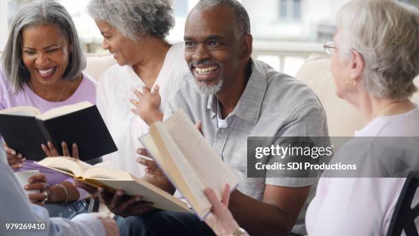 senior man leidt bijbelstudie in pensionering gemeenschap - bible society stockfoto's en -beelden