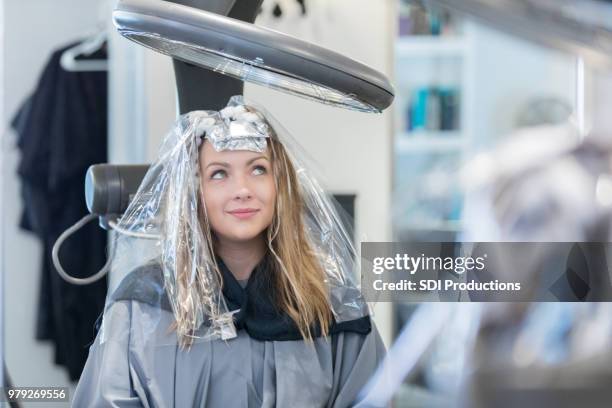 beautiful hair salon customer waiting on color to set - reflexo cabelo pintado imagens e fotografias de stock