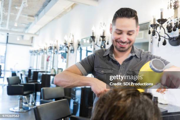 hair stylist blow dries woman's hair - male hairdresser stock pictures, royalty-free photos & images