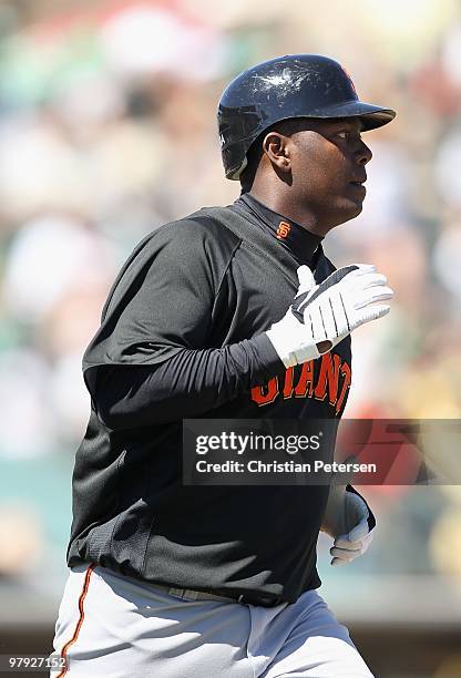 Edgar Renteria of the San Francisco Giants runs to first base during the MLB spring training game against the Oakland Athletics at Phoenix Municipal...