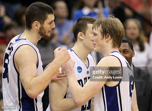 Kyle Singler of the Duke Blue Devils is greeted by Brian Zoubek after leaving late in the game against the California Golden Bears during the second...