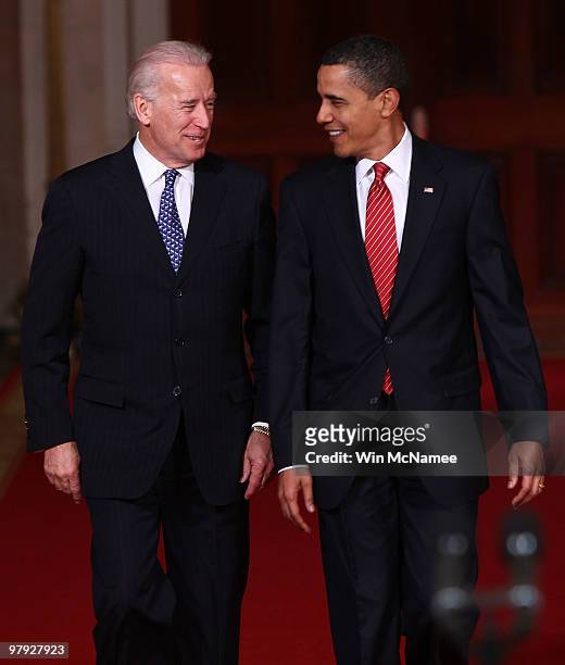 President Barack Obama walks with Vice President Joe Biden to speak from the East Room of the White House after passage of his health care reform...