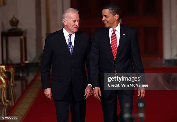 President Barack Obama walks with Vice President Joe Biden to speak from the East Room of the White House after passage of his health care reform...