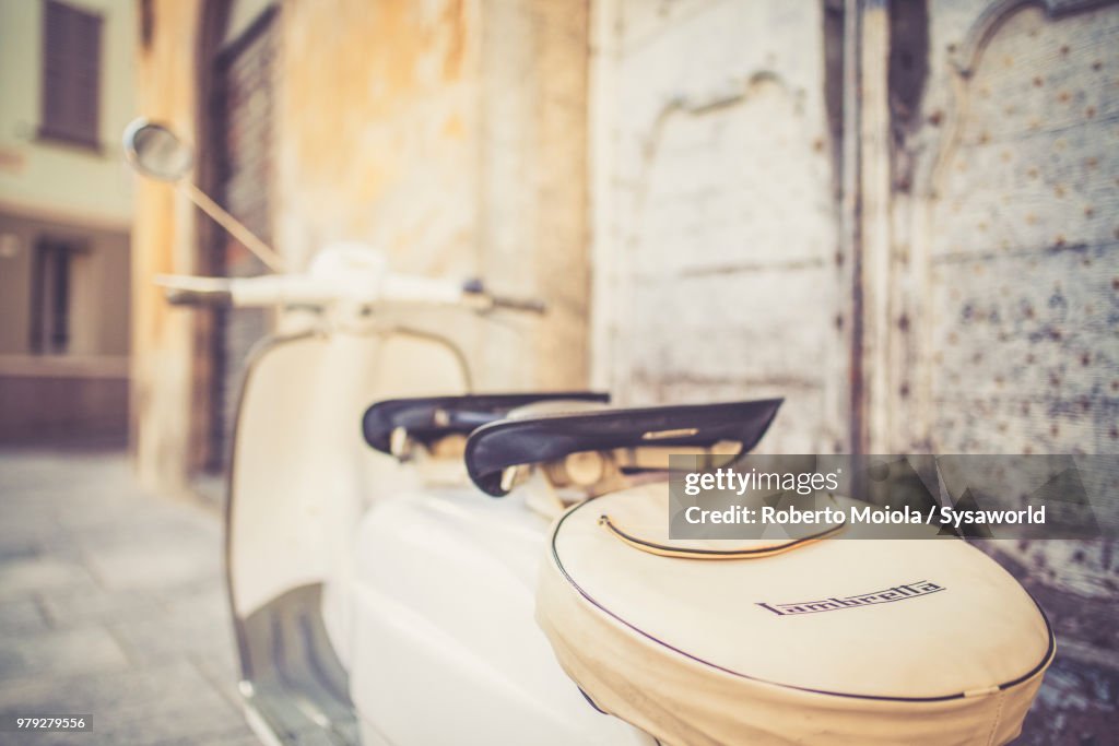 Spare wheel of white iconic vintage motor scooter Lambretta Innocenti parked in the old town of Morbegno, province of Sondrio, Valtellina, Lombardy, Italy