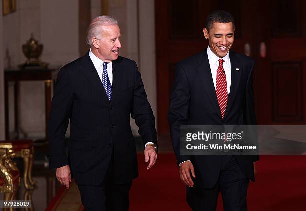 President Barack Obama walks with Vice President Joseph Biden to speak from the East Room of the White House after passage of his health care reform...