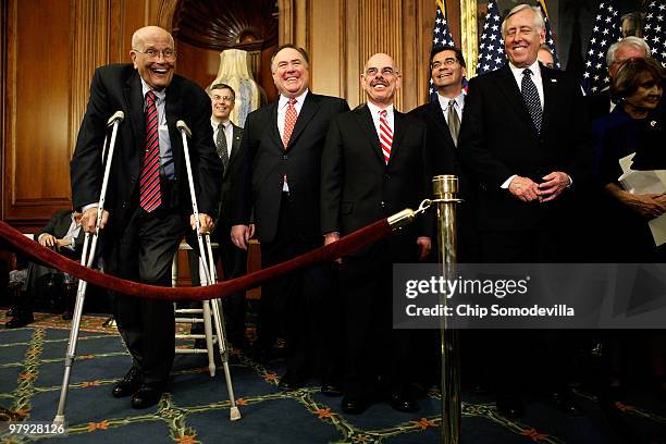 Rep. John Dingell leans on crutches and has a laugh with other members of the House Democratic leadership after the House passed health care reform...