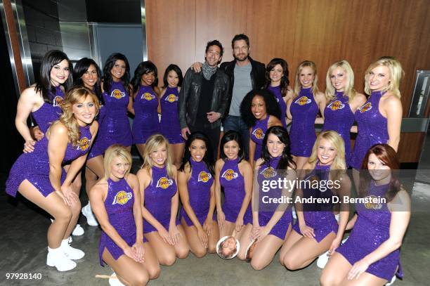 Actors Adrien Brody and Gerard Butler pose for a photograph with the Los Angeles Laker Girls following a game between the Washington Wizards and the...