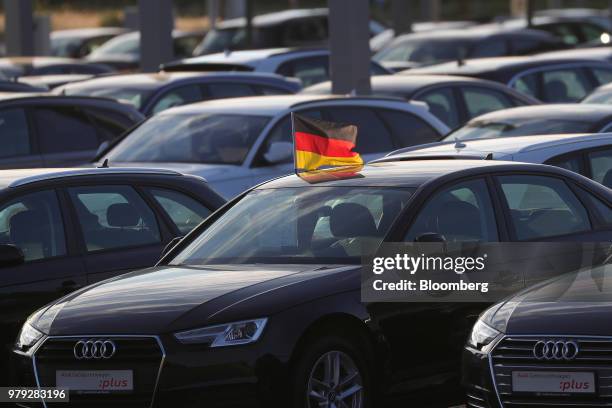 German national flag flies from a used Audi AG A4 automobile on the forecourt of the automaker's showroom in Berlin, Germany, on Tuesday, June 19,...