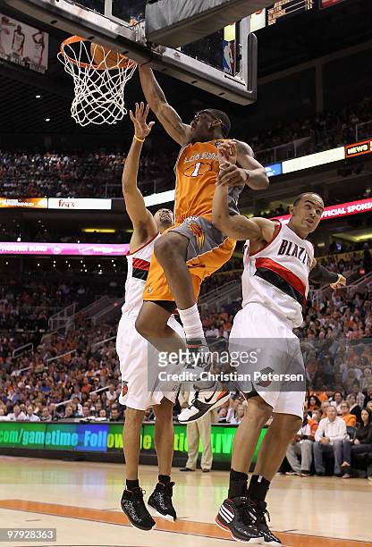Amar'e Stoudemire of the Phoenix Suns slam dunks the ball between Juwan Howard and Jerryd Bayless of the Portland Trail Blazers during the NBA game...