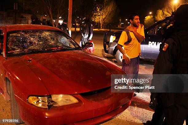 Man who was injured when his windshield was smashed with rocks speaks with the police on March 21, 2010 in Juarez, Mexico. The border city of Juarez...