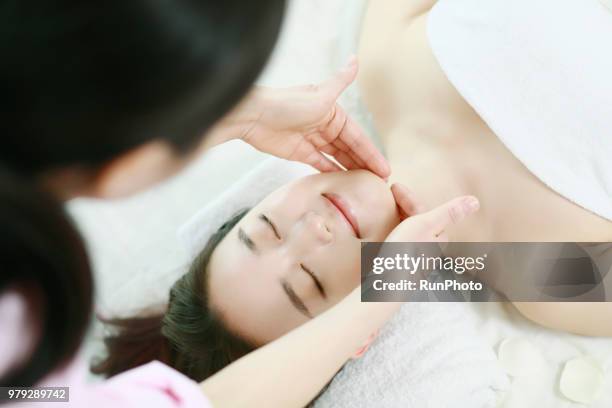 young woman receiving facial massage - body massage japan stock pictures, royalty-free photos & images