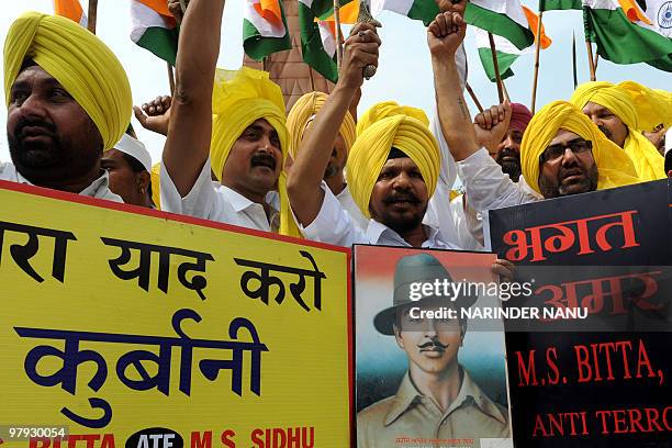 All India Anti Terrorism Front activists wave Indian flags and hold a photograph of Shaheed-e-Azam Bhagat Singh, the day prior to his 79th death...