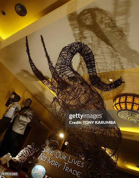 -- This picture taken on May 18, 2007 in Nairobi, Kenya, shows people walking past an Elephant sculpture made of wire from snares confiscated by the...