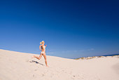 female exercising on a sand dune