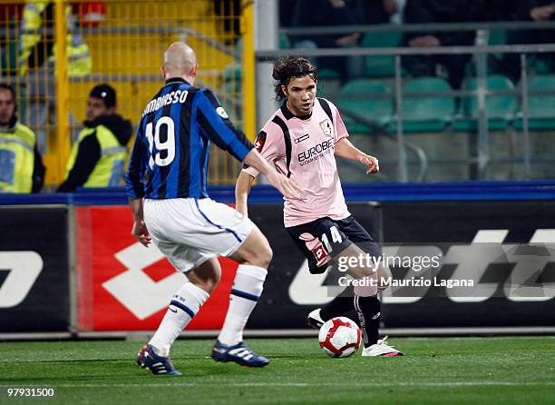 Nicolas Bertolo of US Citta' di Palermo battles for the ball with Esteban Cambiasso of FC Internazionale Milano during the Serie A match between US...