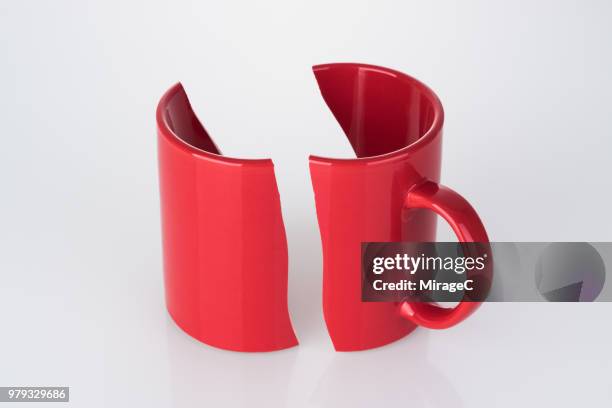 halved damaged red mug cup - broken cup stock-fotos und bilder