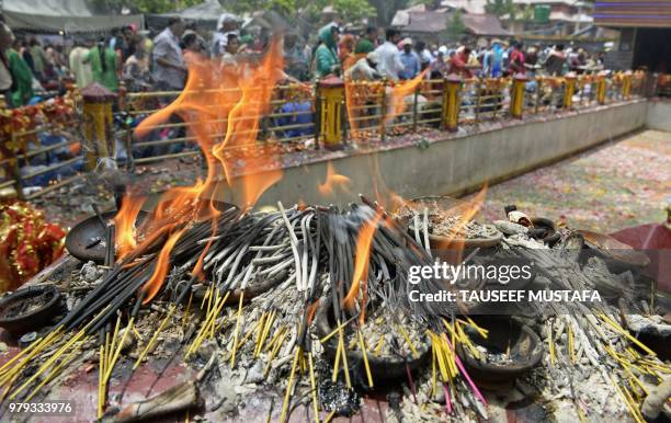 Kashmiri Pandits offer prayers as joss sticks burn at the Mata Kheer Bhawani Temple during its annual festival in the village of Tullamulla, some 20...