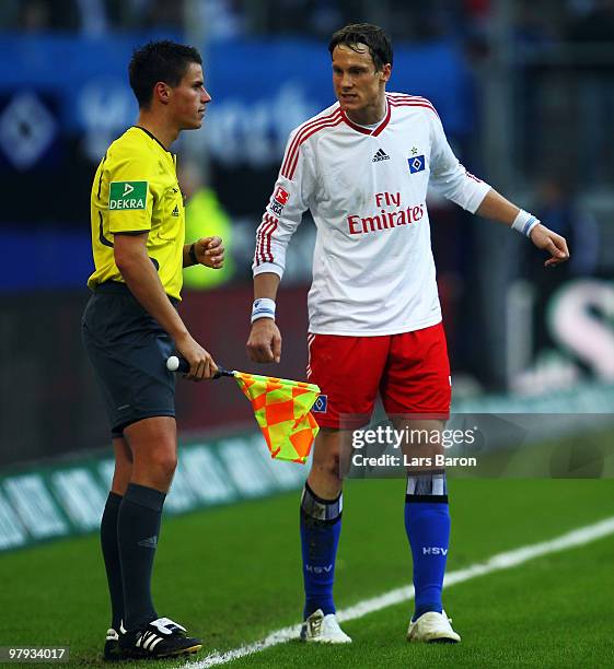 Marcell Jansen of Hamburg discusses with assistant referee Robert Kempter during the Bundesliga match between Hamburger SV and FC Schalke 04 at HSH...