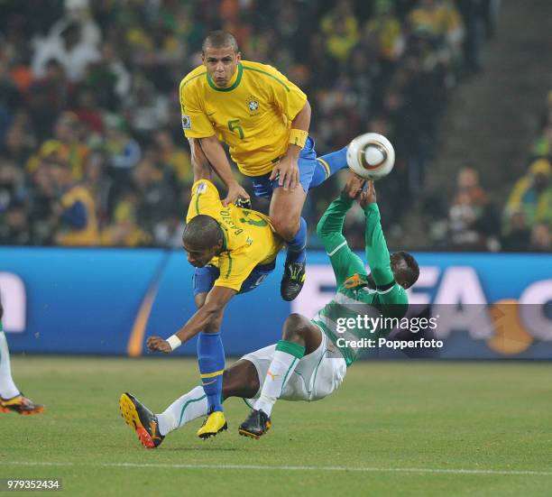 Felipe Melo and Michel Bastos of Brazil collide with Aruna Dindane of the Ivory Coast during a FIFA World Cup Group G match at the Soccer City...